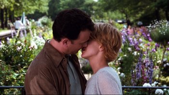 Movie still from “You've Got Mail” (1998), directed by Nora Ephron – A man and a woman kissing in front of flowers; Close Up shot, Over the shoulder angle