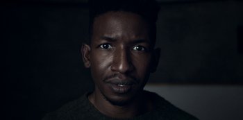 Movie still from “Archive 81” (2022), created by Rebecca Sonnenshine – A person wearing a green shirt; Close Up shot, Low angle