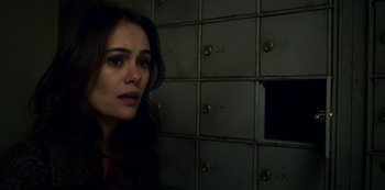 Movie still from “Archive 81” (2022), created by Rebecca Sonnenshine – A woman standing in front of a wall of lockers; Close Up shot, High angle
