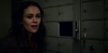 Movie still from “Archive 81” (2022), created by Rebecca Sonnenshine – A woman standing in front of a bunch of lockers; Close Up shot, Low angle