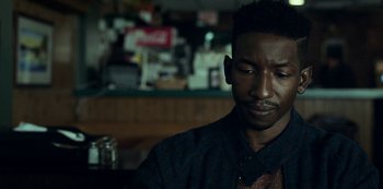 Movie still from “Archive 81” (2022), created by Rebecca Sonnenshine – A person sitting at a table; Close Up shot, Over the shoulder angle