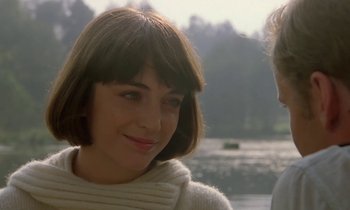 A young woman with short brown hair wearing a white sweater