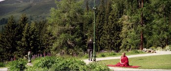 Movie still from “Youth” (2015), directed by Paolo Sorrentino – Two people sitting on the ground near a street light; Extreme Wide shot, High angle