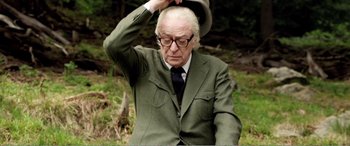 Movie still from “Youth” (2015), directed by Paolo Sorrentino – An older man in a suit and tie holding a hat; Close Up shot, Low angle