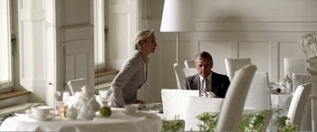 Movie still from “Youth” (2015), directed by Paolo Sorrentino – A woman standing at a dinner table talking to a man in a suit; Medium shot, Over the shoulder angle