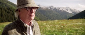 Movie still from “Youth” (2015), directed by Paolo Sorrentino – An older man wearing glasses and a hat in a field; Close Up shot, Over the shoulder angle