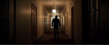 Movie still from “Youth” (2015), directed by Paolo Sorrentino – A man standing in a hallway of a building; Wide shot, Low angle
