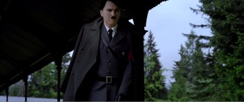 Movie still from “Youth” (2015), directed by Paolo Sorrentino – A man in a suit and tie holding an umbrella; Medium shot, Low angle