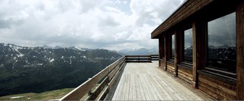 Movie still from “Youth” (2015), directed by Paolo Sorrentino – A wooden deck with a view of a mountain range; Extreme Wide shot, High angle