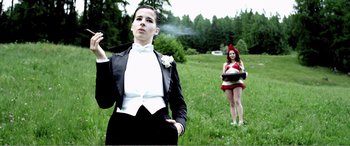 Movie still from “Youth” (2015), directed by Paolo Sorrentino – A man in a tuxedo standing next to a woman in a red dress; Medium shot, Low angle