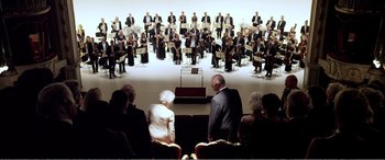 Movie still from “Youth” (2015), directed by Paolo Sorrentino – A group of people sitting in front of an orchestra; Extreme Wide shot, Low angle