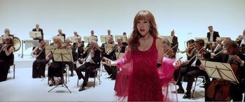 Movie still from “Youth” (2015), directed by Paolo Sorrentino – A woman in a red dress holding a white stick; Medium shot, Low angle