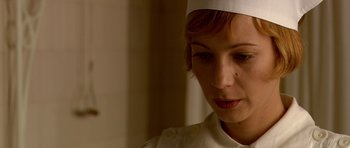Movie still from “Youth Without Youth” (2007), directed by Francis Ford Coppola – A woman wearing a white hat looking down; Close Up shot, Low angle