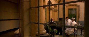Movie still from “Youth Without Youth” (2007), directed by Francis Ford Coppola – A man sitting on a chair in front of a window; Wide shot, High angle