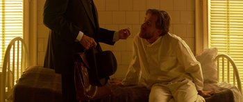 Movie still from “Youth Without Youth” (2007), directed by Francis Ford Coppola – A man in white shirt and black hat talking to another man in black suit; Medium shot, Over the shoulder angle