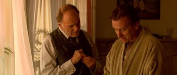 Movie still from “Youth Without Youth” (2007), directed by Francis Ford Coppola – Two men standing next to each other in a room; Medium shot, Over the shoulder angle