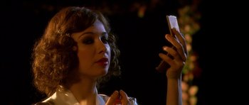 Movie still from “Youth Without Youth” (2007), directed by Francis Ford Coppola – A woman looking at her cell phone in a dark room; Close Up shot, Over the shoulder angle