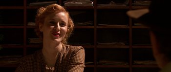 Movie still from “Youth Without Youth” (2007), directed by Francis Ford Coppola – A woman with red hair sitting in front of shelves; Close Up shot, Over the shoulder angle