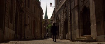 Movie still from “Youth Without Youth” (2007), directed by Francis Ford Coppola – A man walking down a street with a church in the background; Wide shot, Low angle