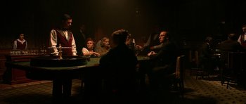 Movie still from “Youth Without Youth” (2007), directed by Francis Ford Coppola – A group of people sitting around a table playing poker; Wide shot, Over the shoulder angle