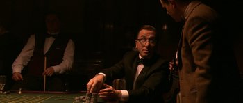 Movie still from “Youth Without Youth” (2007), directed by Francis Ford Coppola – A man sitting at a poker table in front of a stack of chips; Medium shot, Over the shoulder angle