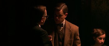 Movie still from “Youth Without Youth” (2007), directed by Francis Ford Coppola – A man in a suit and a bow tie talking to another man in a suit; Close Up shot, Over the shoulder angle