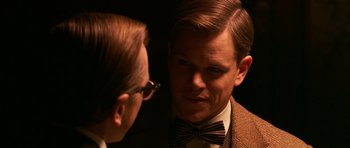 Movie still from “Youth Without Youth” (2007), directed by Francis Ford Coppola – A man wearing a bow tie talking to another man wearing glasses; Close Up shot, Over the shoulder angle