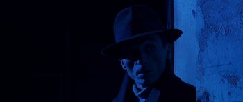 Movie still from “Youth Without Youth” (2007), directed by Francis Ford Coppola – A man wearing a hat and sunglasses in the dark; Close Up shot, Low angle