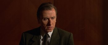 Movie still from “Youth Without Youth” (2007), directed by Francis Ford Coppola – A person wearing a suit and tie; Close Up shot, Over the shoulder angle