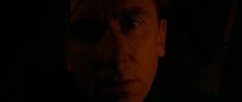 Movie still from “Youth Without Youth” (2007), directed by Francis Ford Coppola – A person's face with a dark background; Extreme Close Up shot, Low angle