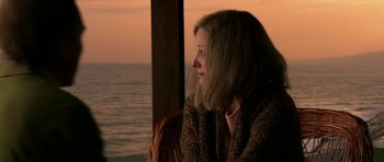 Movie still from “Youth Without Youth” (2007), directed by Francis Ford Coppola – A woman sitting on a chair looking out at the ocean; Close Up shot, High angle