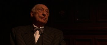 Movie still from “Youth Without Youth” (2007), directed by Francis Ford Coppola – An older man in a suit and bow tie; Close Up shot, Low angle