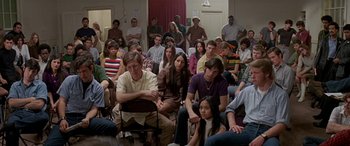 Movie still from “Zabriskie Point” (1970), directed by Michelangelo Antonioni – A large group of people sitting in a room; Wide shot, High angle