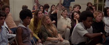 Movie still from “Zabriskie Point” (1970), directed by Michelangelo Antonioni – A group of people sitting and standing in a room; Medium shot, High angle