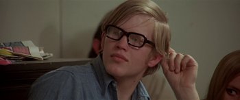 Movie still from “Zabriskie Point” (1970), directed by Michelangelo Antonioni – A young man wearing glasses looking to his left; Close Up shot, Over the shoulder angle
