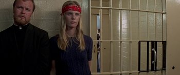 Movie still from “Zabriskie Point” (1970), directed by Michelangelo Antonioni – A woman with a red bandanna standing in front of a jail cell; Medium shot, Low angle