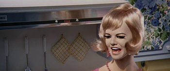 Movie still from “Zabriskie Point” (1970), directed by Michelangelo Antonioni – A woman in a pink dress in front of an oven; Close Up shot, Low angle