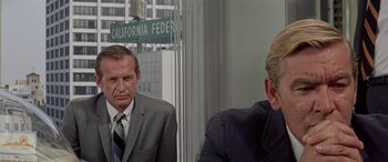 Movie still from “Zabriskie Point” (1970), directed by Michelangelo Antonioni – A man in a suit and tie sitting next to another man in a suit and tie; Close Up shot, Over the shoulder angle