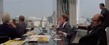 Movie still from “Zabriskie Point” (1970), directed by Michelangelo Antonioni – Two people sitting at a table in a conference room; Wide shot, Over the shoulder angle