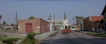 Movie still from “Zabriskie Point” (1970), directed by Michelangelo Antonioni – A red truck driving down a street next to buildings; Extreme Wide shot, Low angle