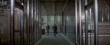 Movie still from “Zabriskie Point” (1970), directed by Michelangelo Antonioni – Two businessmen walking down a hallway in a building; Wide shot, Low angle