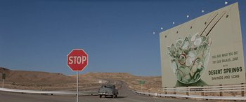 Movie still from “Zabriskie Point” (1970), directed by Michelangelo Antonioni – A stop sign and a car on the side of the road; Extreme Wide shot, Low angle