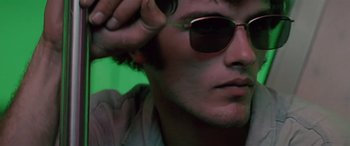 Movie still from “Zabriskie Point” (1970), directed by Michelangelo Antonioni – A person wearing a pair of sunglasses; Close Up shot, Low angle