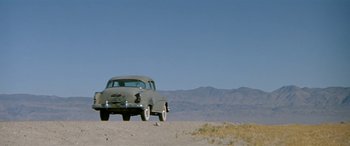 Movie still from “Zabriskie Point” (1970), directed by Michelangelo Antonioni – An old car parked on the side of a road; Extreme Wide shot, Low angle