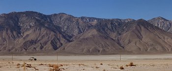 Movie still from “Zabriskie Point” (1970), directed by Michelangelo Antonioni – A view of a desert with mountains in the background; Extreme Wide shot, Low angle