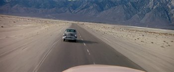 Movie still from “Zabriskie Point” (1970), directed by Michelangelo Antonioni – A car driving down the middle of a road; Extreme Wide shot, High angle