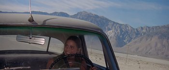 Movie still from “Zabriskie Point” (1970), directed by Michelangelo Antonioni – A woman sitting in the driver's seat of a car; Medium shot, Low angle
