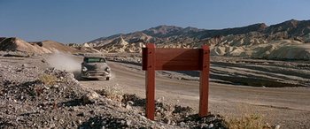 Movie still from “Zabriskie Point” (1970), directed by Michelangelo Antonioni – A wooden sign in the middle of the desert; Extreme Wide shot, Low angle