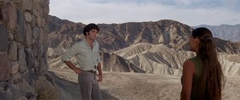 Movie still from “Zabriskie Point” (1970), directed by Michelangelo Antonioni – A man standing on top of a hill in the desert; Wide shot, Low angle