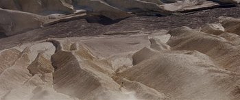 Movie still from “Zabriskie Point” (1970), directed by Michelangelo Antonioni – A person riding skis on top of a snow covered slope; Extreme Wide shot, High angle